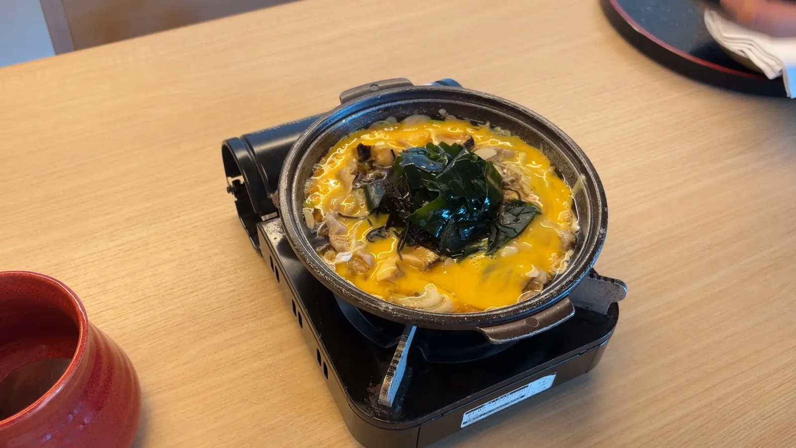 卓上コンロにかけられた、卵でとじたあらめ磯鍋