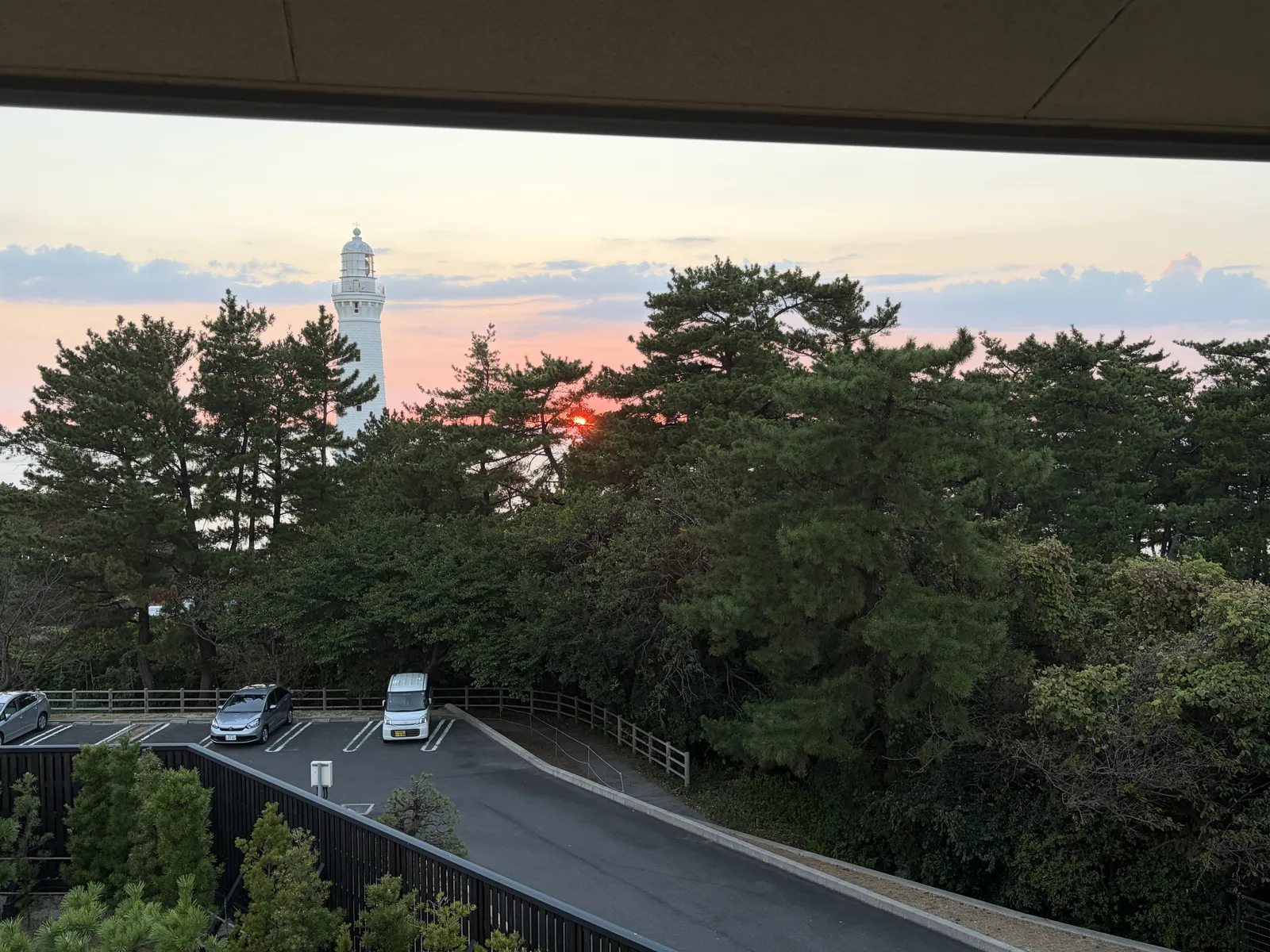 客室の窓から見た、夕焼け空と松林の向こうの日御碕灯台
