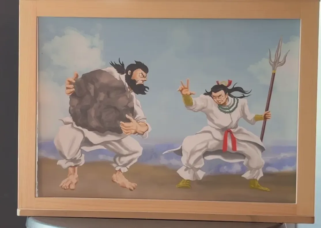 大きな岩を抱えた神と、矛を持つ神が向き合う紙芝居の絵