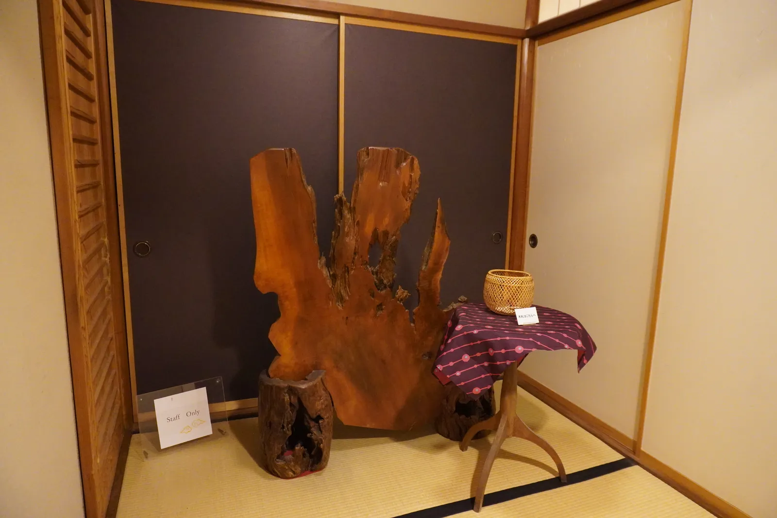 木の根の飾りと花かごが置かれた床の間
