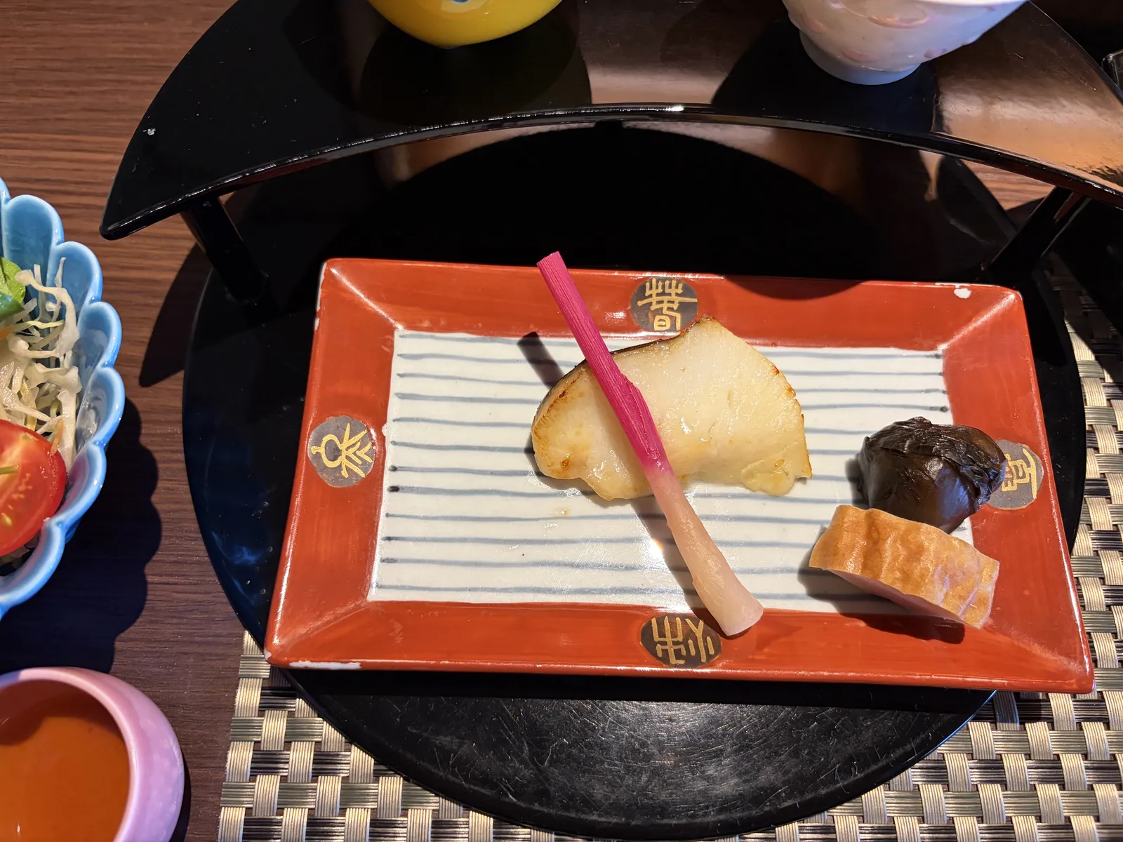 朱色の角皿にのった焼き魚