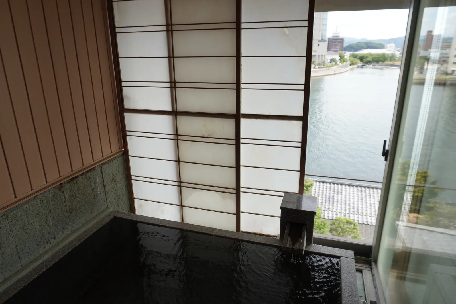 窓の外に宍道湖が見える、石造りの客室の展望風呂
