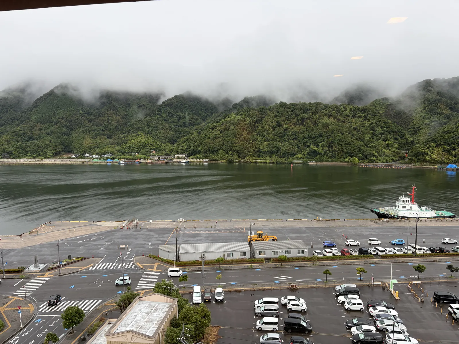 本棚コーナーの窓から見た境水道と対岸の山並み、手前の駐車場